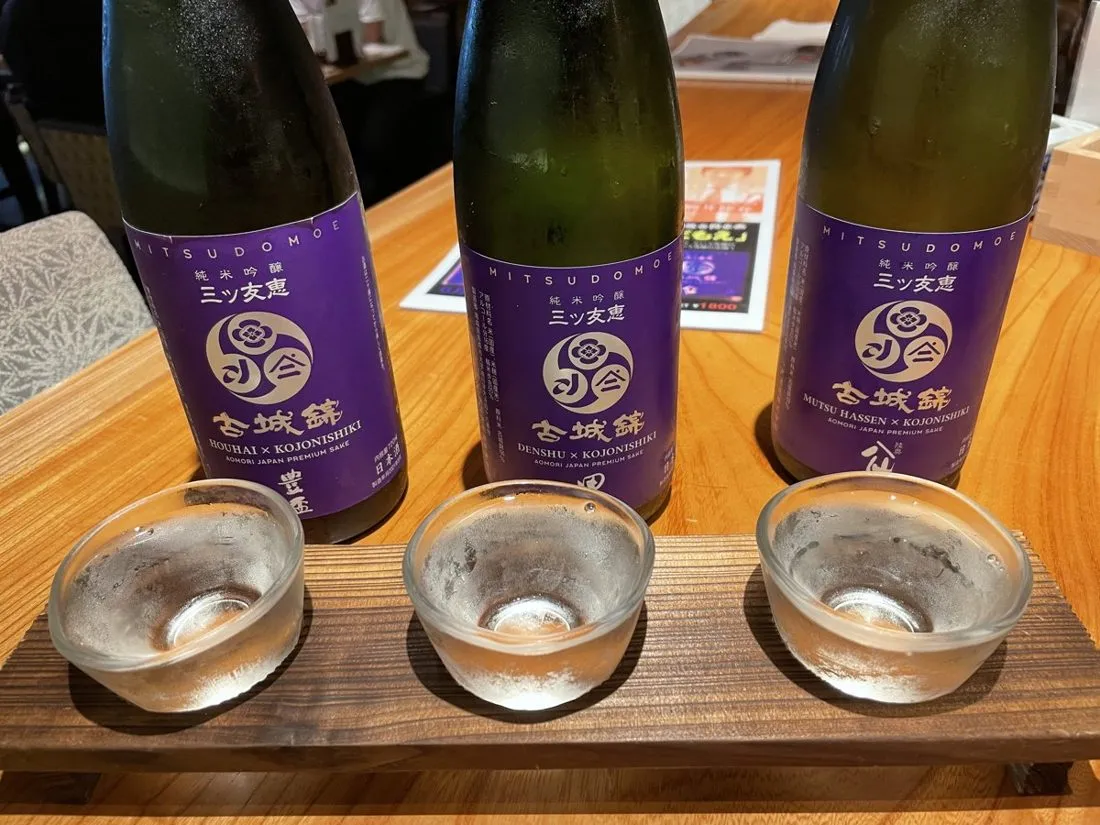 Sake bottles and cups set out on a counter at a Tokyo izakaya