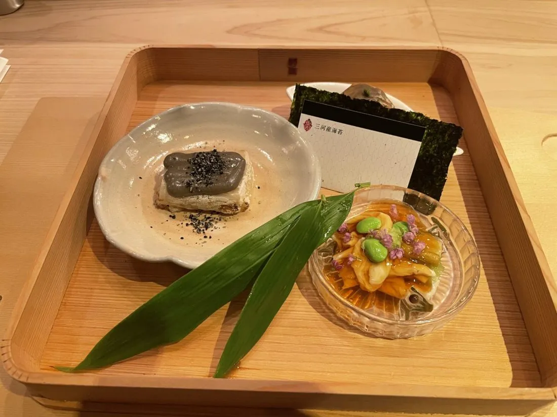 Small shared dishes on a wooden tray at a Tokyo counter restaurant