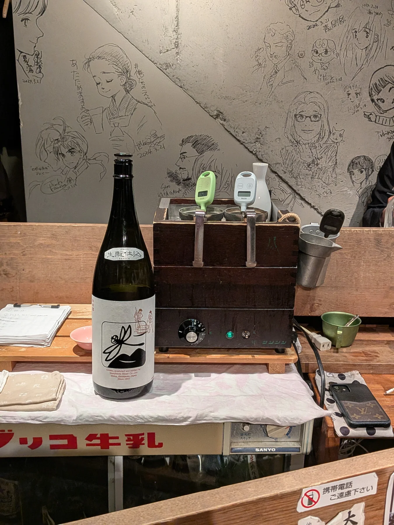 Izumibashi bottle beside the sake-warming device at Enrai