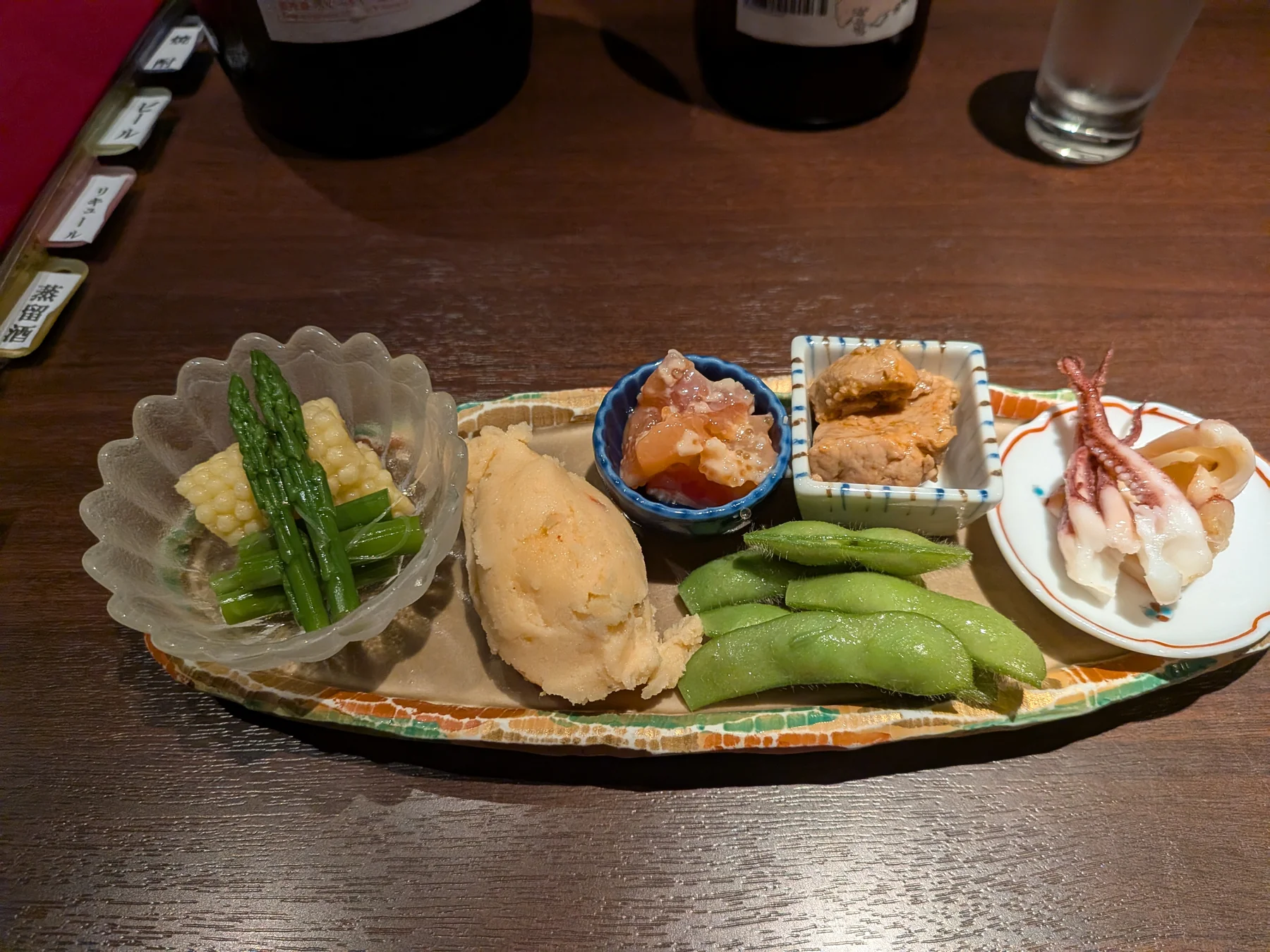 Assorted appetizers at Kuri Ginza, including sakura shrimp potato salad